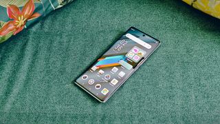 An Infinix Note 40 Pro Plus smartphone on a green sofa